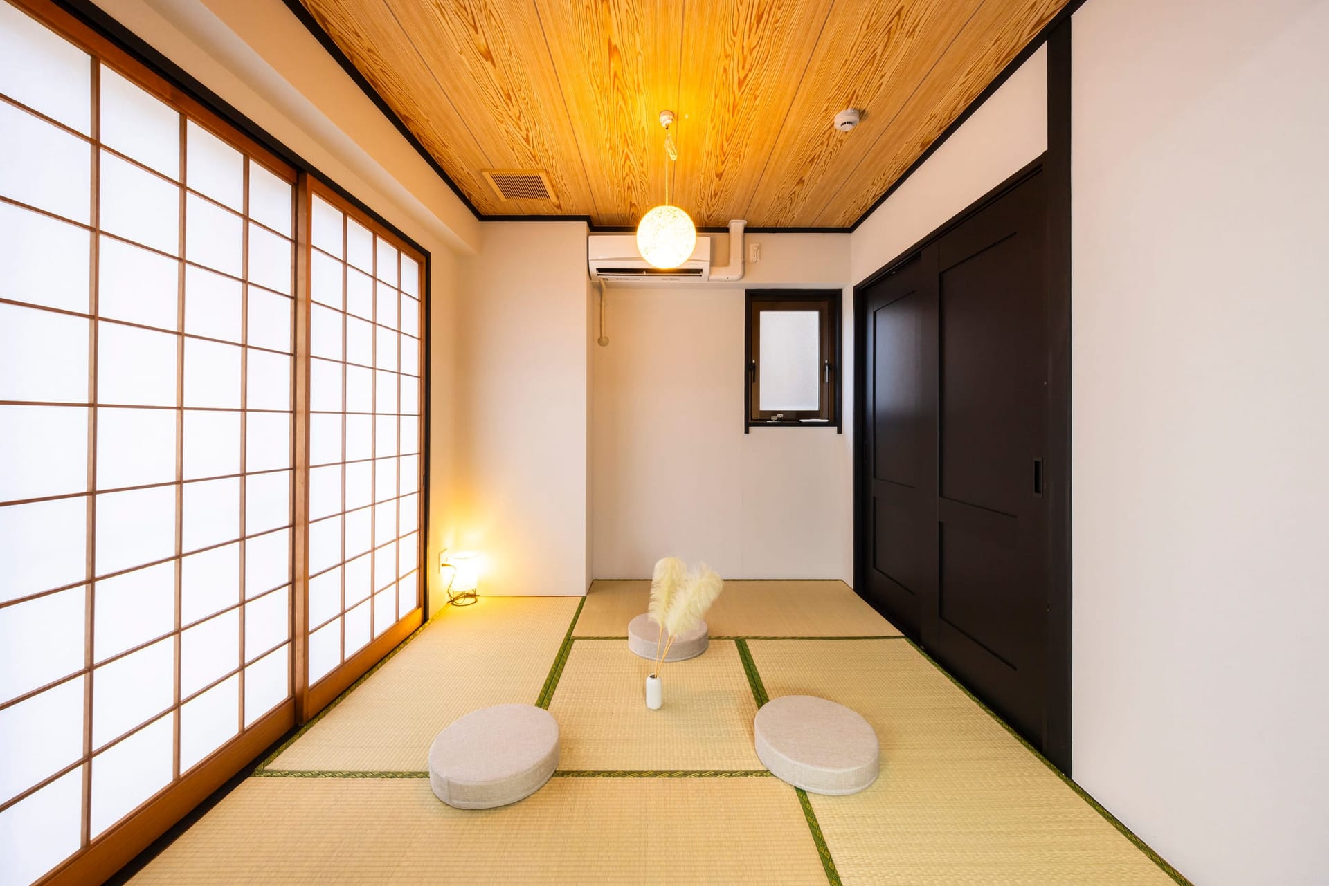 和室。障子ごしのやわらかい光と畳、座布団